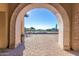 A view of the community pool area through a stone archway, showcasing the relaxing amenity at 8729 E Indigo St, Mesa, AZ 85207