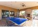 Covered patio space with ping pong table, fireplace, ceiling fan, and comfortable seating at 8729 E Indigo St, Mesa, AZ 85207