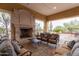 Relaxing covered patio with a stone fireplace and comfortable seating area at 8729 E Indigo St, Mesa, AZ 85207