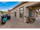 Charming side patio with brick pavers, seating for two, and potted plants at 8729 E Indigo St, Mesa, AZ 85207