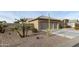 Side view of a tan house with a two-car garage and desert landscaping at 9321 E Diamond Dr, Sun Lakes, AZ 85248