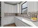 Bright and spacious pantry with white cabinets and brick backsplash at 9846 E Resistance Ave, Mesa, AZ 85212