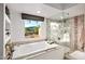 Spa-like bathroom with soaking tub, glass shower, and mountain views at 9901 E Hidden Valley Rd, Scottsdale, AZ 85262