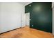 Bedroom with dark green accent wall and hardwood floors at 9916 E Dolphin Cir, Mesa, AZ 85208