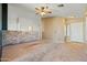 Spacious living room with neutral walls and carpet, a stone accent wall and ceiling fan at 9916 E Dolphin Cir, Mesa, AZ 85208