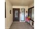 Home entryway with an ornate door and sidelights, welcome decor and red flowers at 10544 W Campana Dr, Sun City, AZ 85351