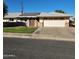 Single story home with solar panels, landscaped lawn, and a two-car garage at 10544 W Campana Dr, Sun City, AZ 85351