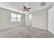 Carpeted bedroom with ceiling fan and ensuite bathroom access at 11026 S 55Th Ln, Laveen, AZ 85339