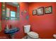 Unique bathroom with a colorful sink, red walls, and framed artwork at 12211 N 57Th St, Scottsdale, AZ 85254