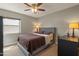 Bright bedroom with a gray upholstered bed and ceiling fan at 12211 N 57Th St, Scottsdale, AZ 85254