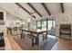 Dining area with wood table and bench, open to kitchen and pool view at 12211 N 57Th St, Scottsdale, AZ 85254