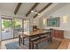 Bright dining room with wooden table and bench, sliding glass doors to patio, and hardwood floors at 12211 N 57Th St, Scottsdale, AZ 85254