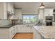 Modern kitchen with stainless steel appliances, white cabinets, and large sink at 12211 N 57Th St, Scottsdale, AZ 85254