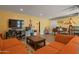 Living area with two orange couches, a coffee table, and entertainment center at 12211 N 57Th St, Scottsdale, AZ 85254