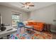 Home office with orange couch, blue armchair, and colorful area rug at 12211 N 57Th St, Scottsdale, AZ 85254