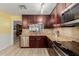 Kitchen with dark wood cabinets, granite countertops, and stainless steel appliances at 1237 E Heather Ave, Gilbert, AZ 85234