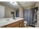 This classic bathroom features a double sink vanity, a large mirror and tub with a shower curtain at 1259 E Canyon Trl, San Tan Valley, AZ 85143