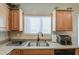 Granite countertops and wood cabinets frame this kitchen, with the sink and faucet in full view at 1259 E Canyon Trl, San Tan Valley, AZ 85143