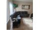 View of living room with tile floor, neutral paint and a comfortable black leather couch at 1259 E Canyon Trl, San Tan Valley, AZ 85143