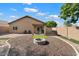 Landscaped backyard with fire pit and patio at 15325 W Port Au Prince Ln, Surprise, AZ 85379