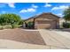 Single-story house with a two-car garage and desert landscaping at 15325 W Port Au Prince Ln, Surprise, AZ 85379