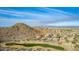 Aerial view of residential homes overlooking a golf course and mountain range at 157 W Latigo Cir, San Tan Valley, AZ 85143