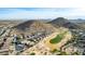 Aerial view showcasing homes surrounding a golf course, nestled against mountains at 157 W Latigo Cir, San Tan Valley, AZ 85143