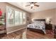 Bright bedroom with wood flooring, a ceiling fan, and large window with plantation shutters at 157 W Latigo Cir, San Tan Valley, AZ 85143