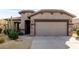 Front view of a tan house with a two-car garage and cacti at 157 W Latigo Cir, San Tan Valley, AZ 85143