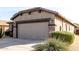 View of a house's two-car garage with desert landscaping at 157 W Latigo Cir, San Tan Valley, AZ 85143