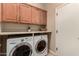 Bright laundry room, washer, dryer, and ample wood cabinets at 157 W Latigo Cir, San Tan Valley, AZ 85143