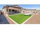 Landscaped backyard with artificial turf, covered patio, and lounge chairs at 16789 S 181St Ln, Goodyear, AZ 85338