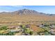 Aerial view showcasing a house, expansive land, and a mountain range at 17642 E Hunt Hwy, Queen Creek, AZ 85142