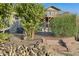 Landscaped backyard with a stone pathway and wood pile at 17642 E Hunt Hwy, Queen Creek, AZ 85142