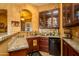 Home wet bar with granite countertops and wood cabinetry at 17721 N Canal Dr, Surprise, AZ 85374