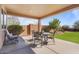 Covered patio with seating for four and a view of the backyard at 18311 E San Ignacio Ct, Gold Canyon, AZ 85118