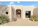 Inviting entryway to a single-story home with a wooden door and large windows at 18702 E Gemmill Dr, Rio Verde, AZ 85263