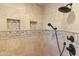 Large walk-in shower with neutral tile and built-in shelving at 18702 E Gemmill Dr, Rio Verde, AZ 85263