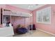 Charming bedroom with a bunk bed, built in shelving and a pink color scheme at 1918 W Bonanza Ln, Phoenix, AZ 85085