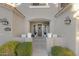 Inviting front entrance with a dark gray door, flanked by planters and white chairs at 1918 W Bonanza Ln, Phoenix, AZ 85085