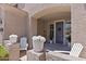 Inviting front entrance with a dark gray door, flanked by planters and white chairs at 1918 W Bonanza Ln, Phoenix, AZ 85085