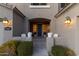 Inviting front entrance with a dark gray door, flanked by planters and white chairs at 1918 W Bonanza Ln, Phoenix, AZ 85085