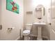 Stylish powder room featuring a pedestal sink and toilet at 2052 N Montclair Ln, Casa Grande, AZ 85122