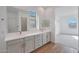 Bathroom featuring double vanity, wood-look tile and two mirrors at 22663 E Happy Rd, Queen Creek, AZ 85142