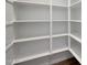 White pantry has organized shelving and wood look flooring at 22663 E Happy Rd, Queen Creek, AZ 85142