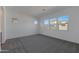 Light-filled bedroom with neutral carpet and view of the neighbor's home through multiple windows at 22670 E Happy Rd, Queen Creek, AZ 85142