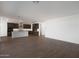 Open-concept living space with wood-look tile flooring and kitchen view at 23128 E Watford Dr, Queen Creek, AZ 85142