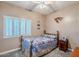 Guest bedroom with full-size bed, ceiling fan, and window shutters at 23619 N 21St St, Phoenix, AZ 85024