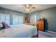 Primary bedroom with king bed, built-in shelves, and ceiling fan at 23619 N 21St St, Phoenix, AZ 85024