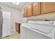 Bright laundry room with white appliances and wood cabinets at 2524 S El Paradiso Dr # 74, Mesa, AZ 85202